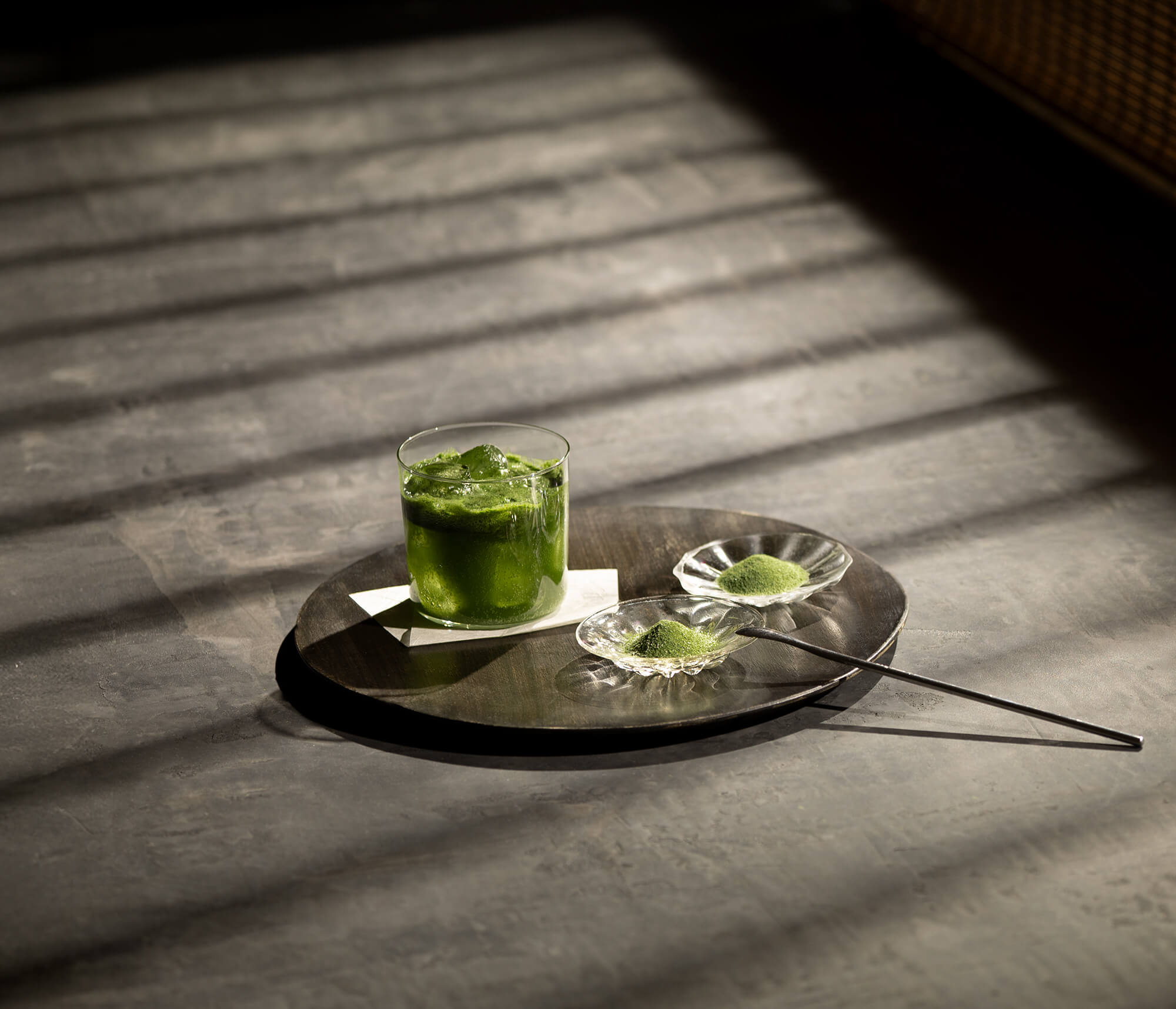 コップにいれた特製青汁と粉末の写真