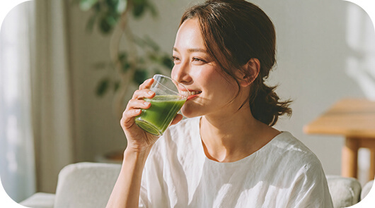 朝に青汁を飲む女性