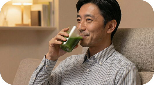夜に青汁を飲む男性