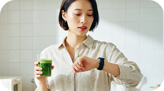忙しい日に青汁を飲む女性